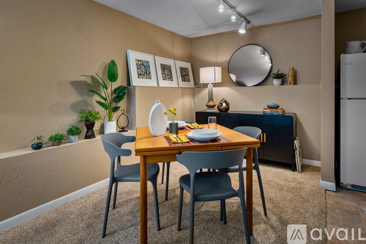 A dining area with a table set for two and a white framed picture on the wall.