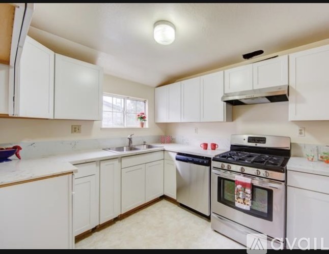 A kitchen with white cabinets and a stainless steel oven.