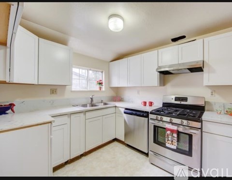 A kitchen with white cabinets and a stainless steel oven.