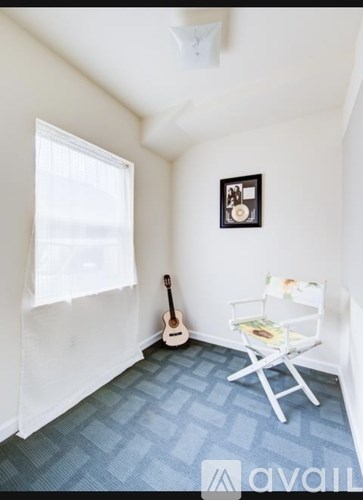 A room with a guitar and a chair.