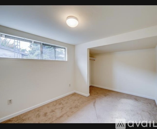 A room with a window and a door is available for rent.