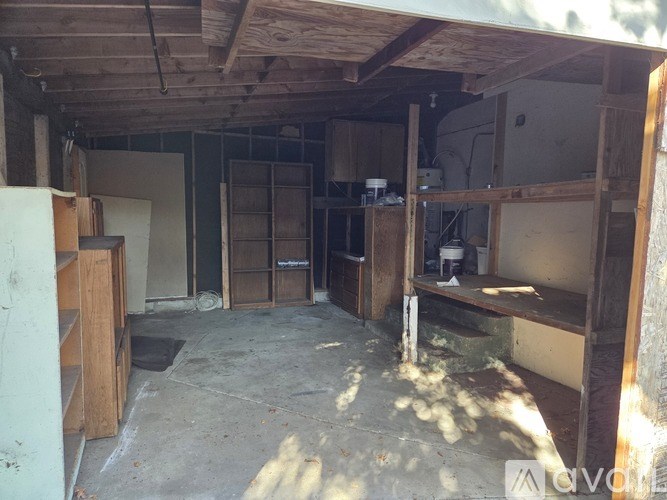 A room with wooden beams on the ceiling and shelves along the walls.