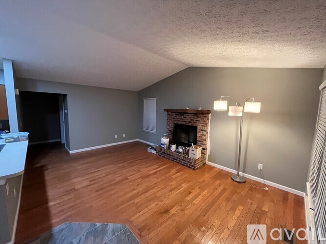 A living room with a fireplace and a grey wall.