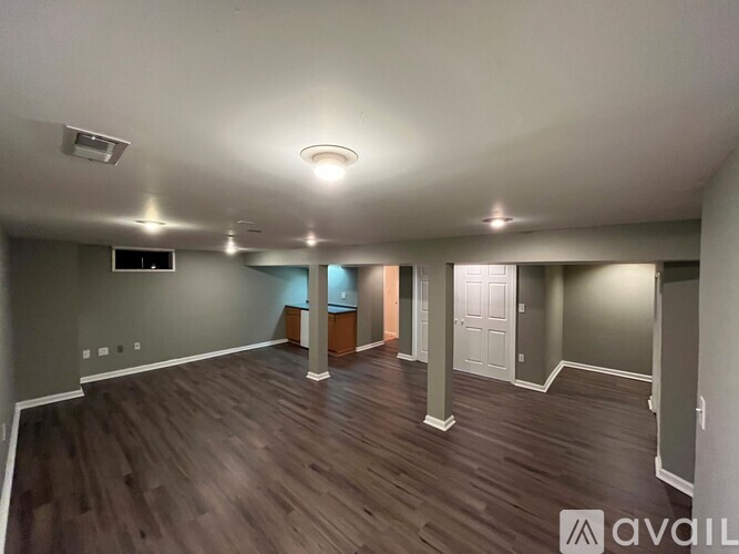 A spacious room with wooden flooring and a flat screen TV mounted on the wall.