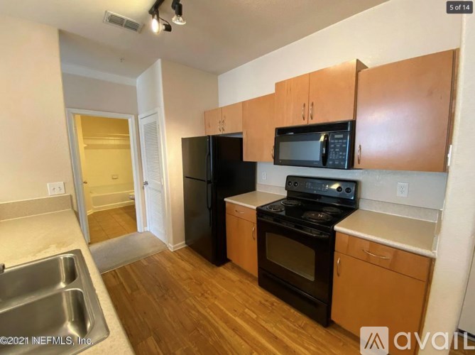 A kitchen with black appliances and wooden cabinets.
