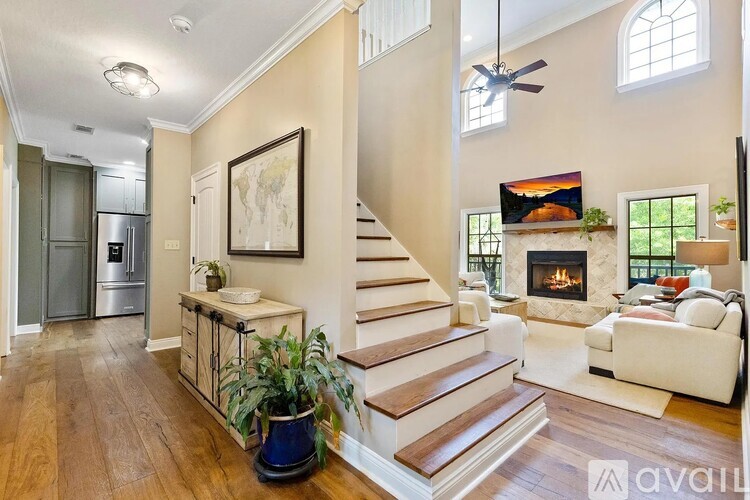 A living room with a staircase and a fireplace.