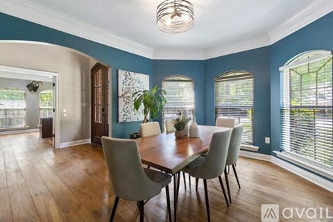A dining room with a wooden table and chairs.