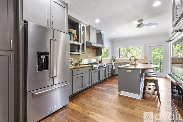 A modern kitchen with stainless steel appliances and wooden floors.