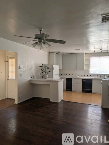 A kitchen with white cabinets and a ceiling fan.