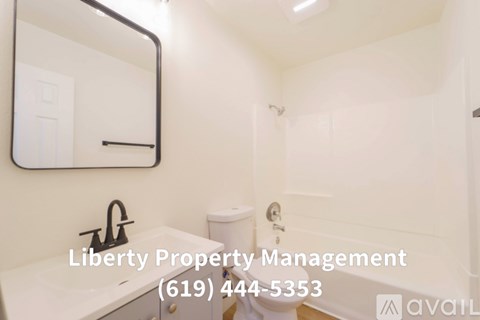 A kitchen with white cabinets and a wooden floor.