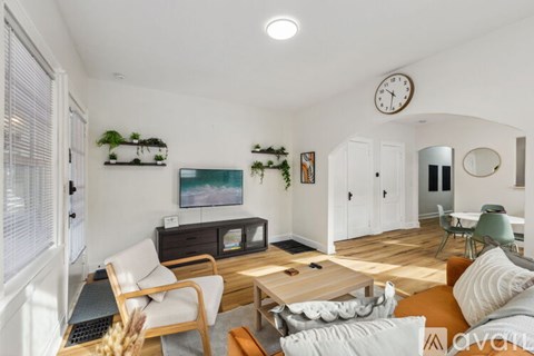 A living room with a couch, chair, and a table.