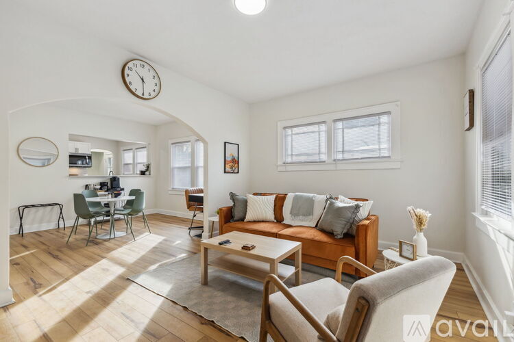 A living room with a couch, chairs, and a dining table.