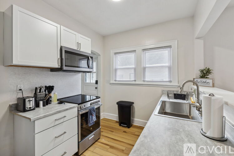 A kitchen with white cabinets and a black stove top.