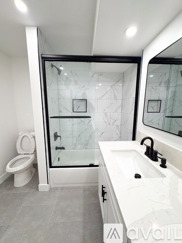 A bathroom with a toilet, sink, and shower.