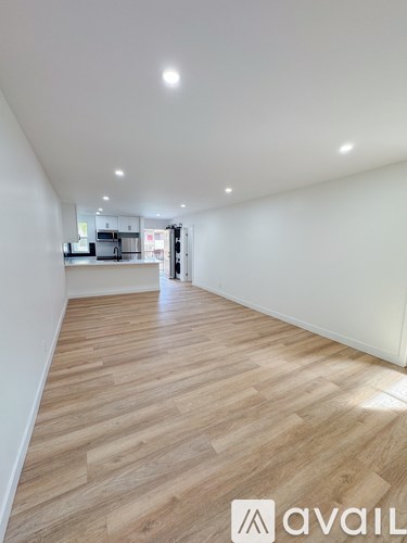 A room with wooden flooring and white walls.