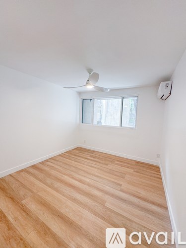 A room with wooden flooring and a ceiling fan.
