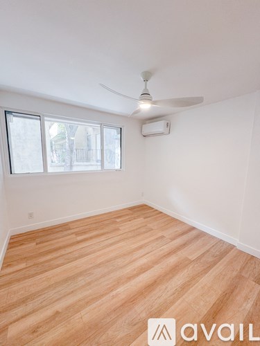 A room with wooden flooring and a ceiling fan.