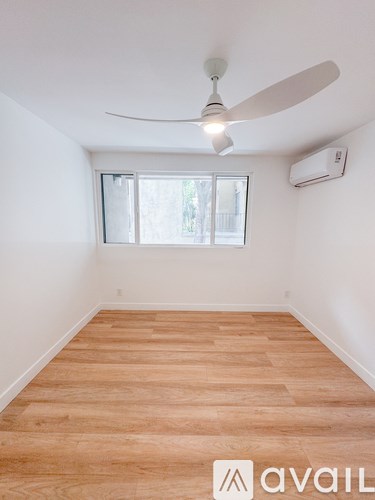 A room with a ceiling fan and a window.