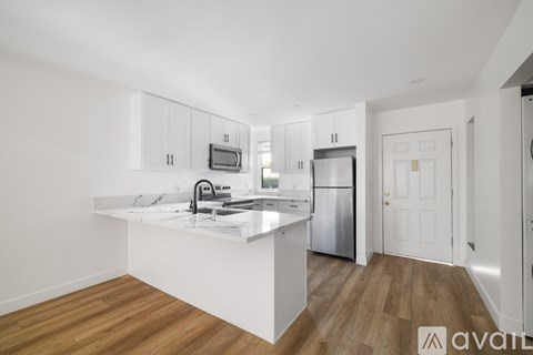 A modern kitchen with a white island and stainless steel appliances.