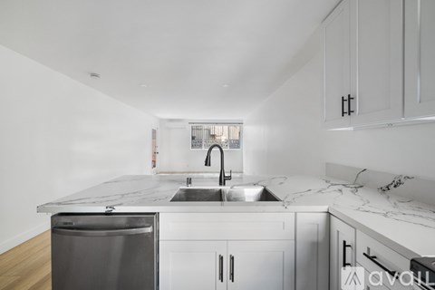 A bathroom with a marble shower and a white vanity.