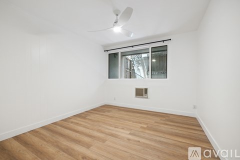 A kitchen with white cabinets and a wooden floor.