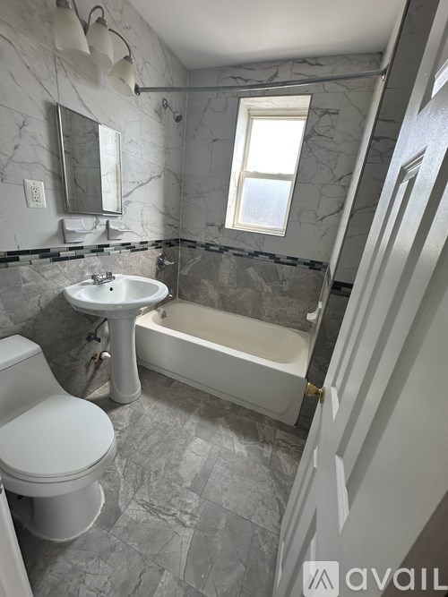 A bathroom with a toilet, sink, and bathtub.