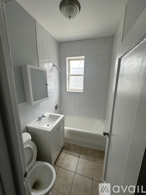 A bathroom with a toilet, sink, and bathtub.