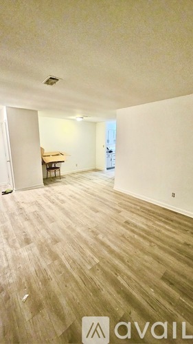 A room with white walls and a door on the left.