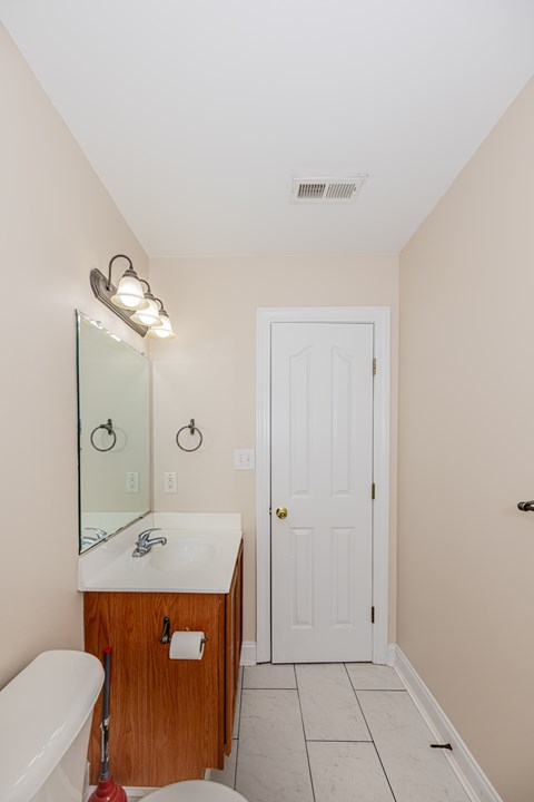 A white door is in a bathroom with a white tub and sink.