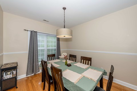 A dining room with a table set for six.