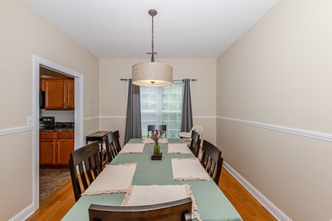 A dining room with a table set for a meal.