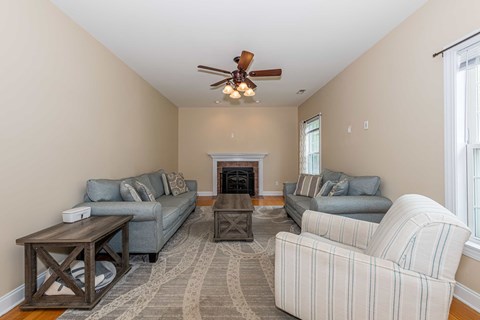 A living room with a fireplace and two couches.