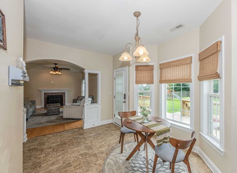 A living room with a fireplace and a dining table set up.
