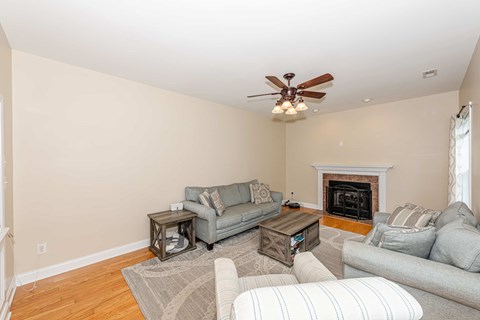 A living room with a grey couch, a coffee table, and a fireplace.