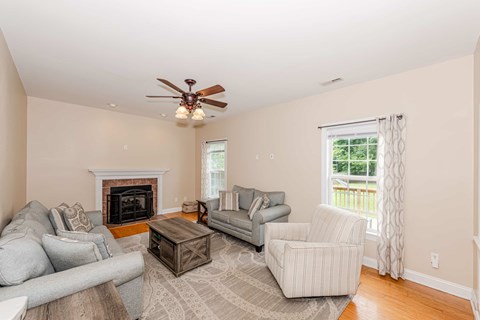 A living room with a grey couch, a coffee table, and a fireplace.