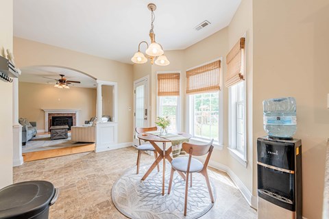A living room with a fireplace and a dining table.