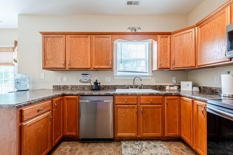 A kitchen with wooden cabinets and a granite countertop.