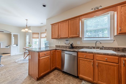 A kitchen with wooden cabinets and a granite countertop.