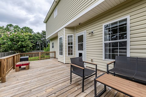 A wooden deck with a bench and a table.