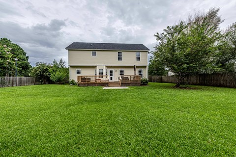 A house with a white fence and a green lawn.