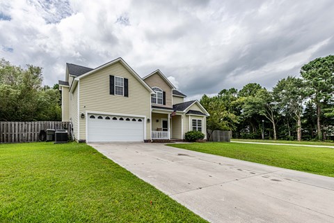 A house with a garage and a driveway in front of it.