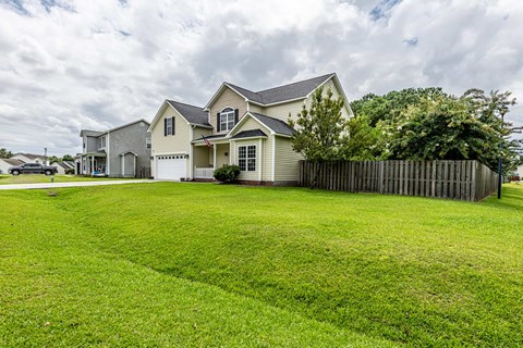 A large house with a fenced yard in front.
