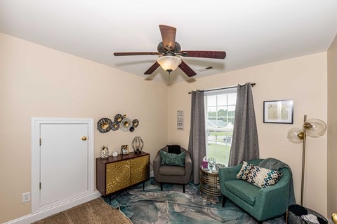 A living room with a green couch, a brown side table, and a white door.