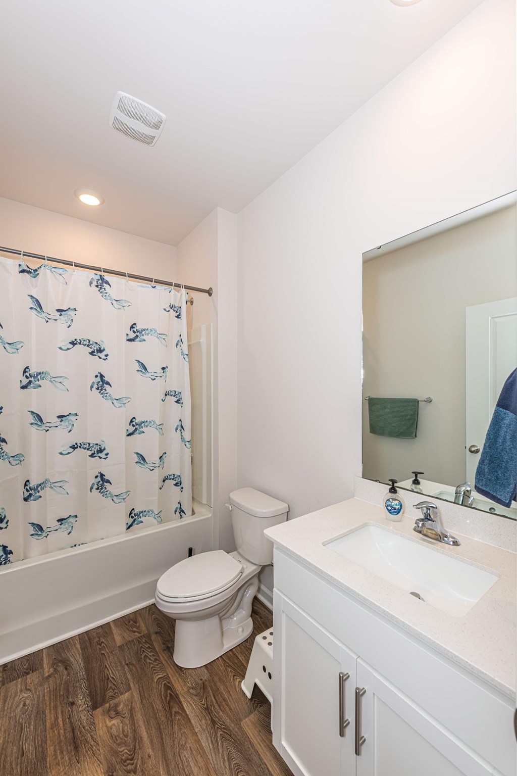 A white bathroom with a toilet, sink, and shower curtain.