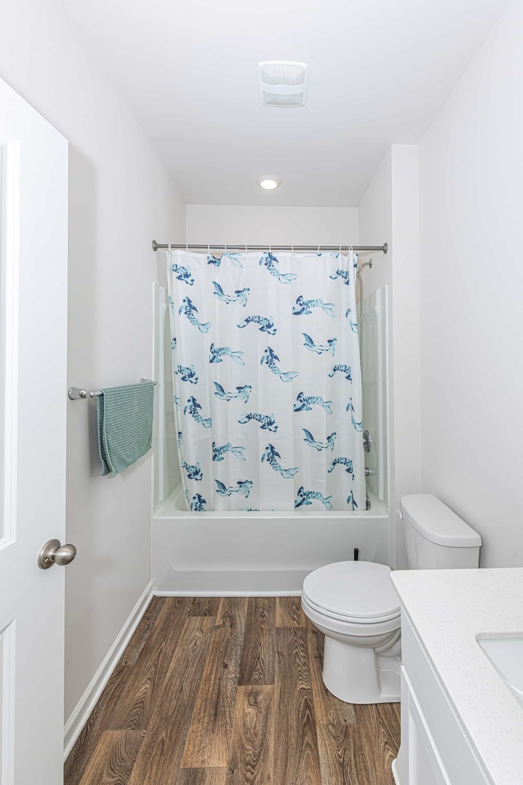 A white toilet sits next to a white sink in a small bathroom.