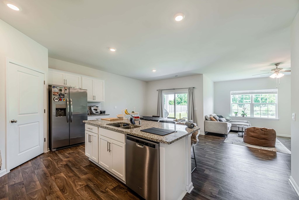 A kitchen with a refrigerator, stove, and sink.
