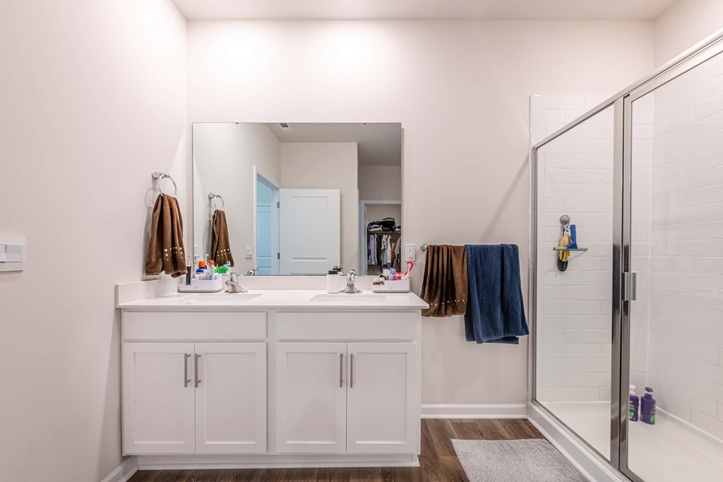A bathroom with a white sink vanity and a mirror above it.