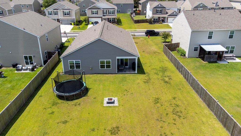 A trampoline is in the front yard of a house.