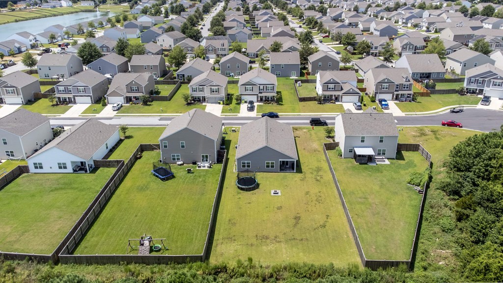 A bird's eye view of a residential area with houses and green lawns.