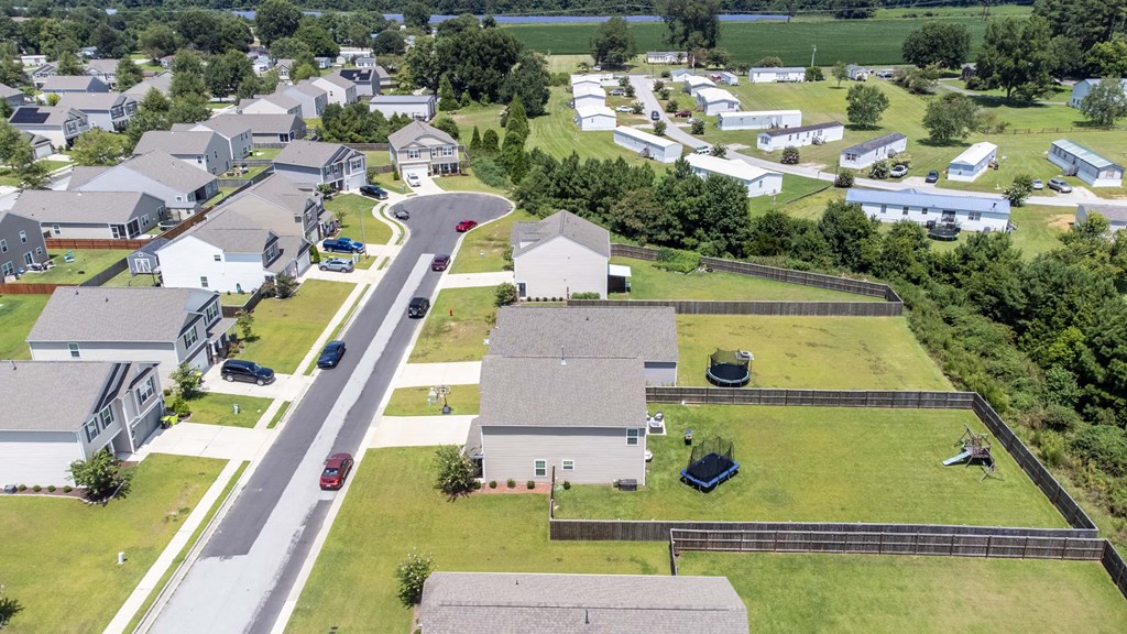 A bird's eye view of a residential area with houses and a road.